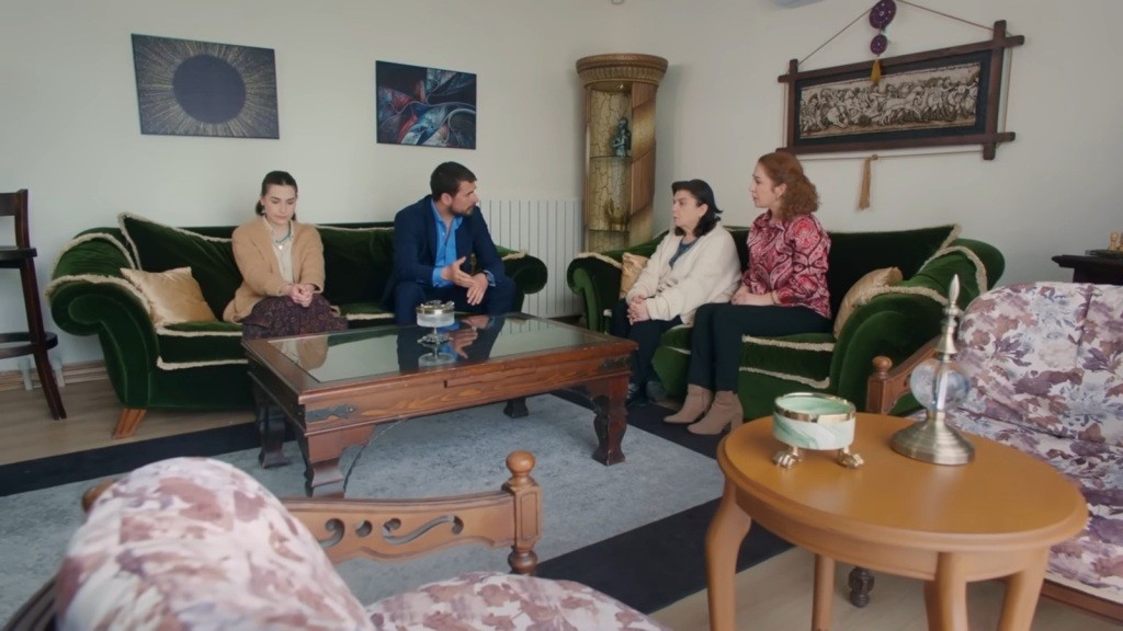 Kuzey rozmawia z mamą i siostrą w salonie. Obok niego siedzi Sili.