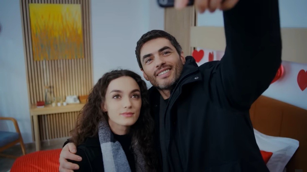 Nana i Poyraz robią wspólne selfie w pokoju hotelowym.