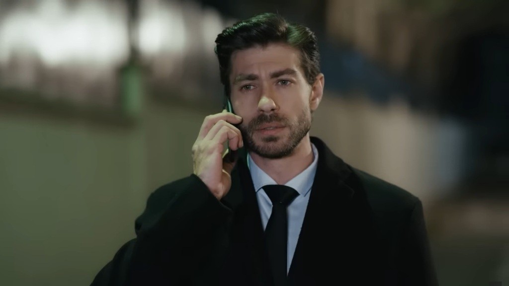 Prokurator Sinan rozmawia przez telefon.