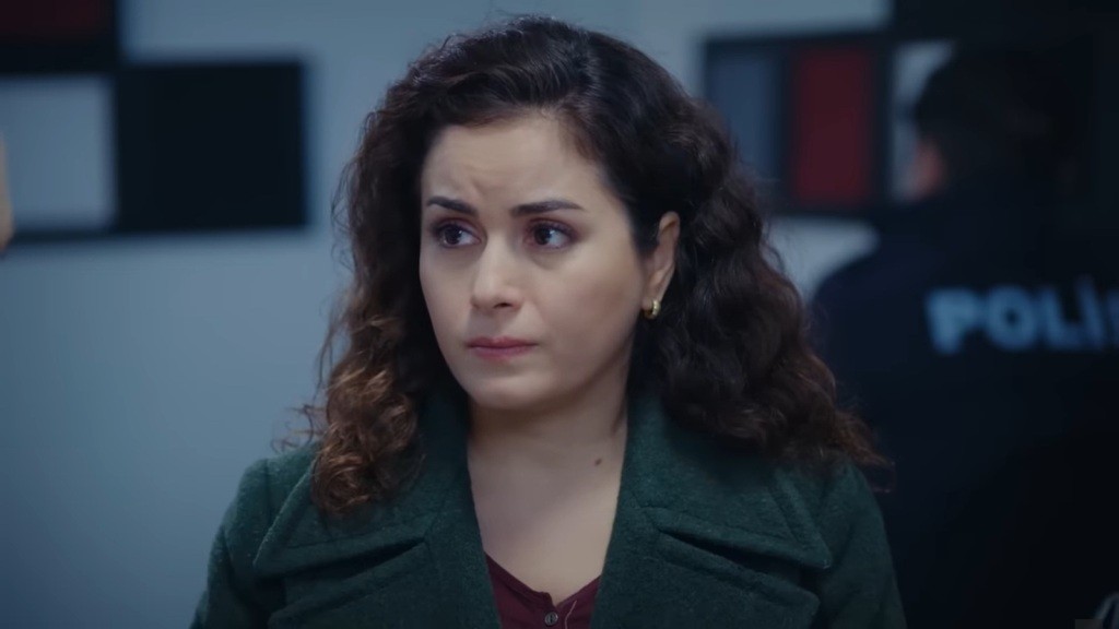 Twarz Aynur wyraża zmartwienie.
