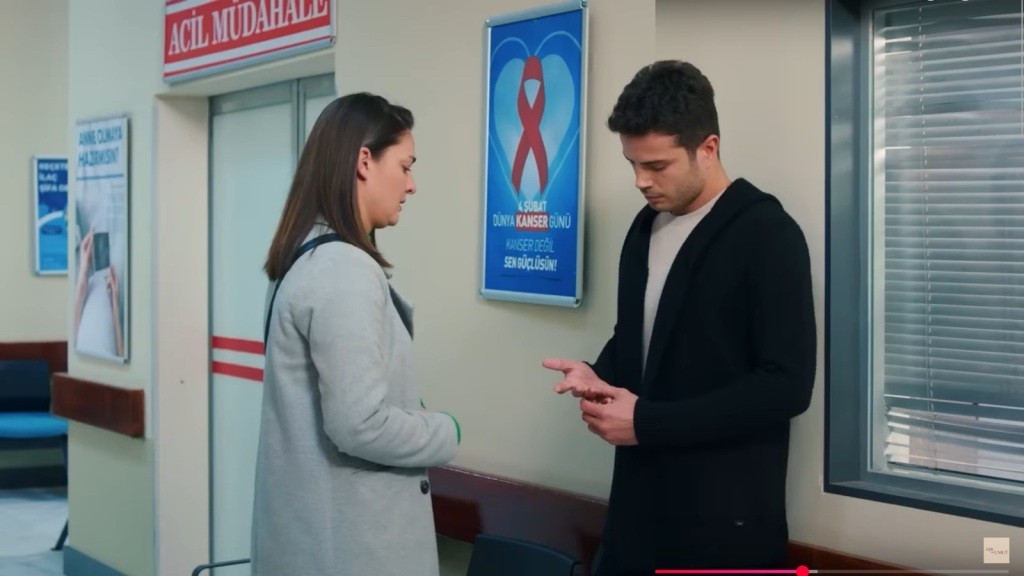 Yildiz i Ege stoją naprzeciwko siebie ze spuszczonymi głowami na szpitalnym korytarzu.