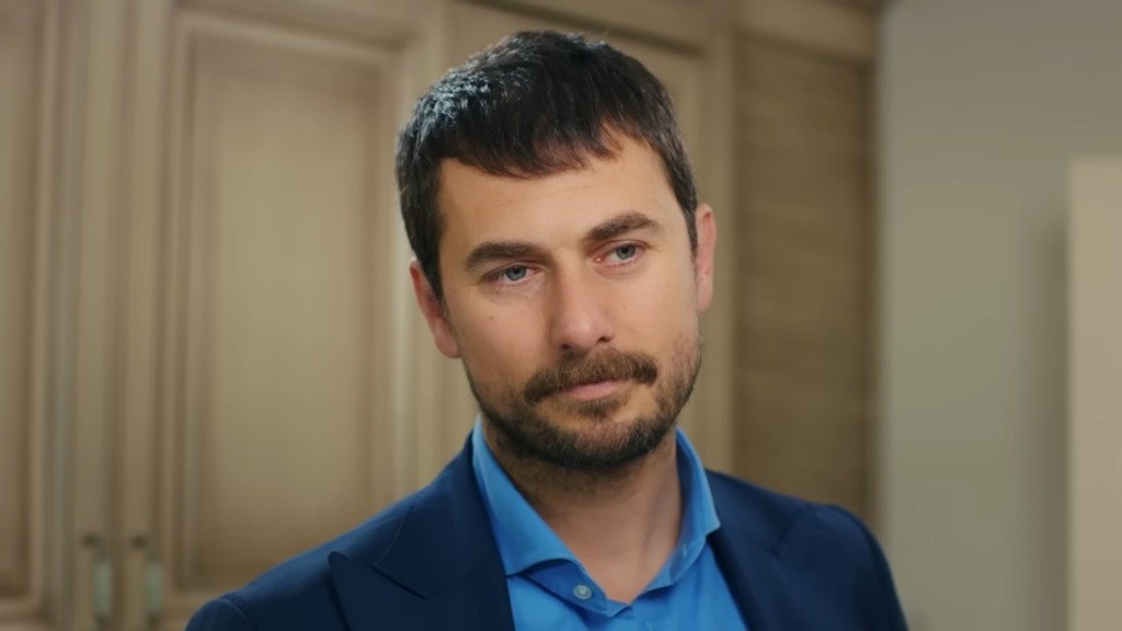 Kuzey spogląda z delikatnym uśmiechem.