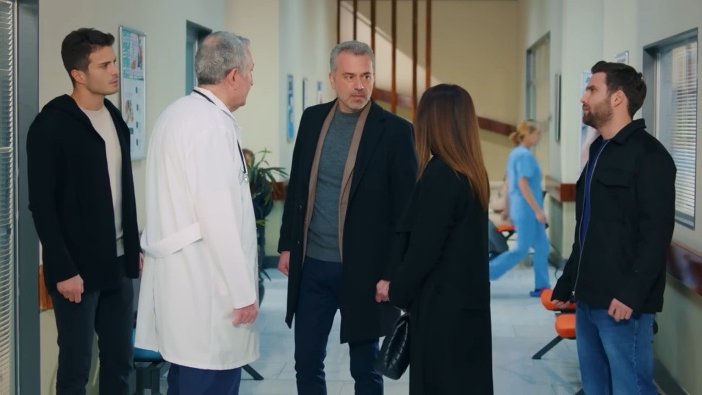 Scena na szpitalnym korytarzu. Bulent i Gonul patrzą na siebie zaskoczeni. Przed nimi stoi doktor. Obok stoją Ege i Arda.