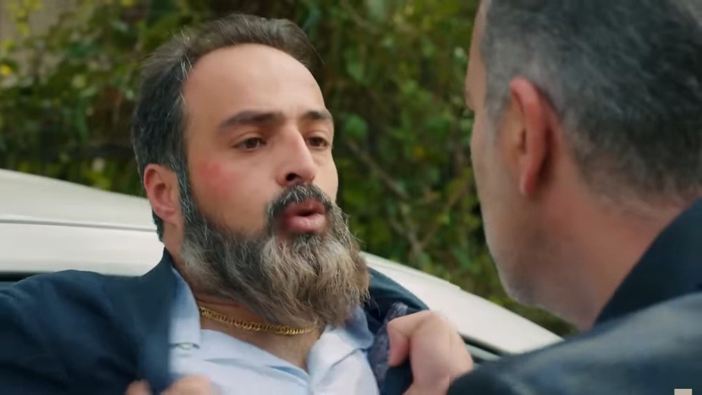 Bulent trzyma Ragipa za poły kurtki.