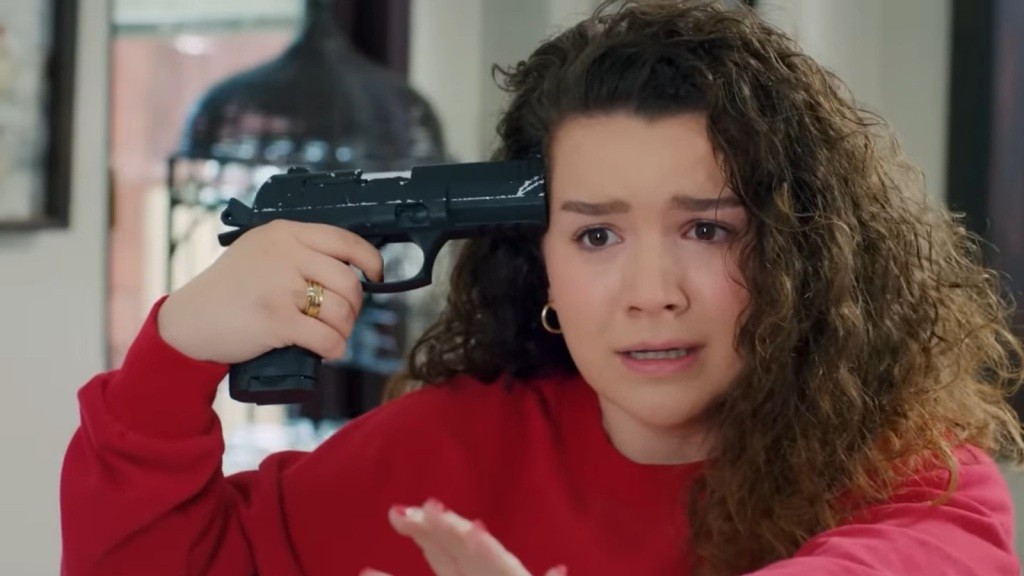 Melis przykłada sobie pistolet do skroni.
