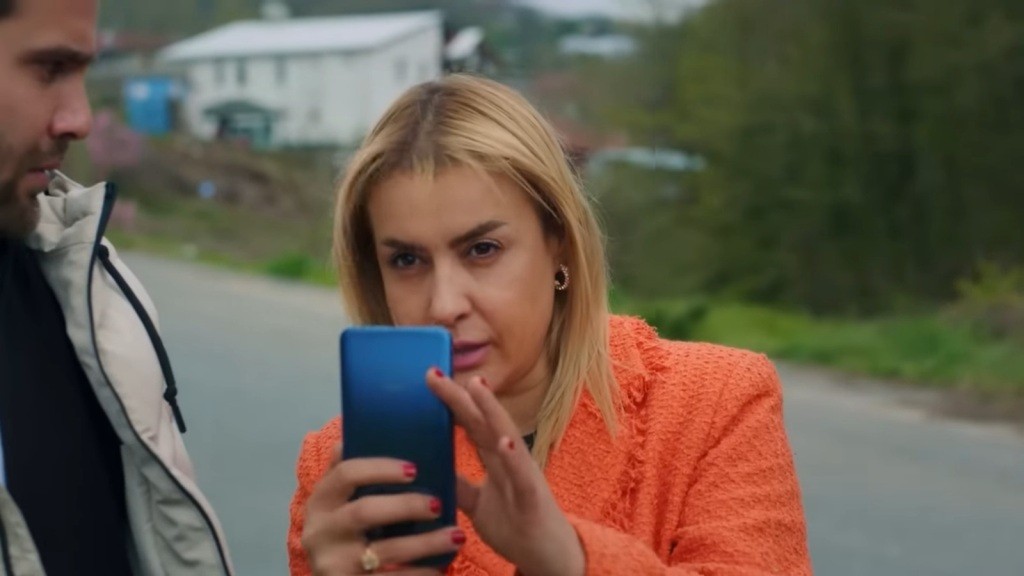 Belkis trzyma telefon odwrócony do góry nogami, próbując nagrywać.