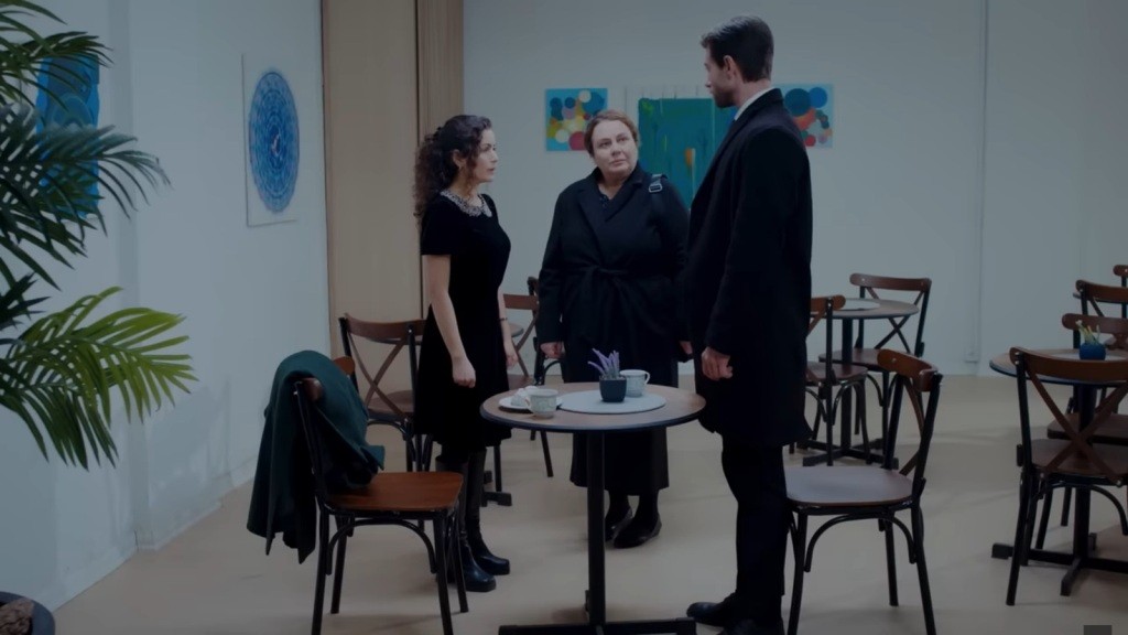 Scena w kawiarni. Aynur, Adalet i Sinan stoją przy stoliku. Adalet spogląda surowo na Sinana.