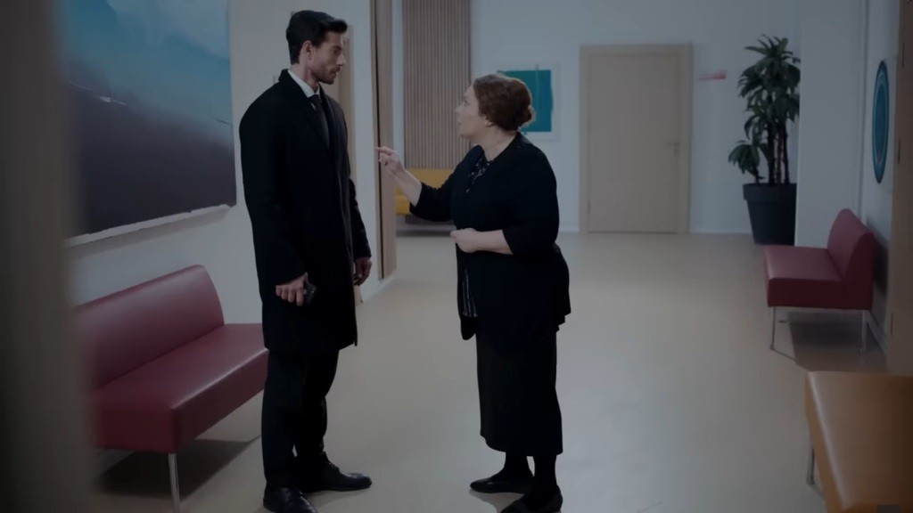 Adalet rozmawia z Sinanem na szpitalnym korytarzu, mierząc palcem wskazującym w jego pierś.