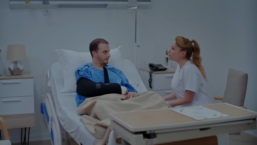 Pielęgniarka siedzi przy łóżku Kivanca.