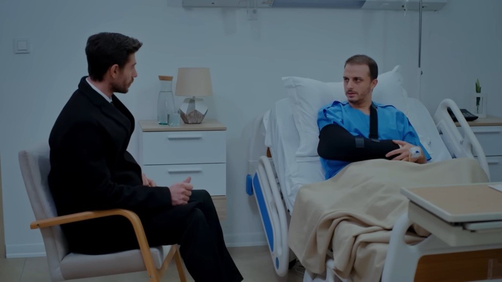 Sinan rozmawia z Kivancem, siedząc przy jego łóżku szpitalnym.