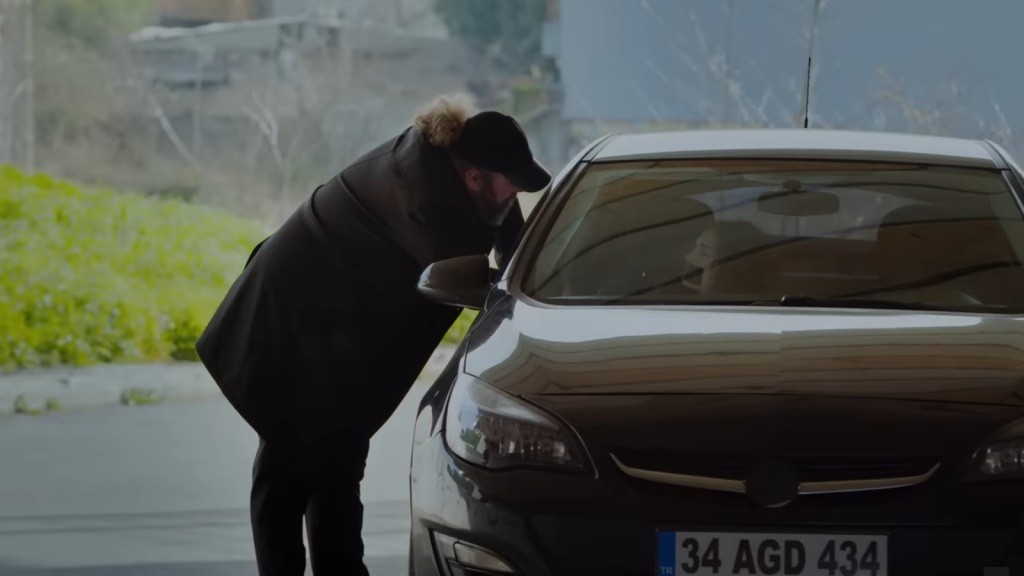 Sedat zagląda do samochodu, w którym znajduje się porwana Nana.