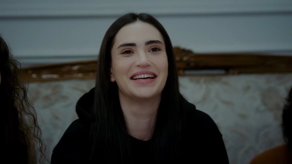 Nazli uśmiecha się.