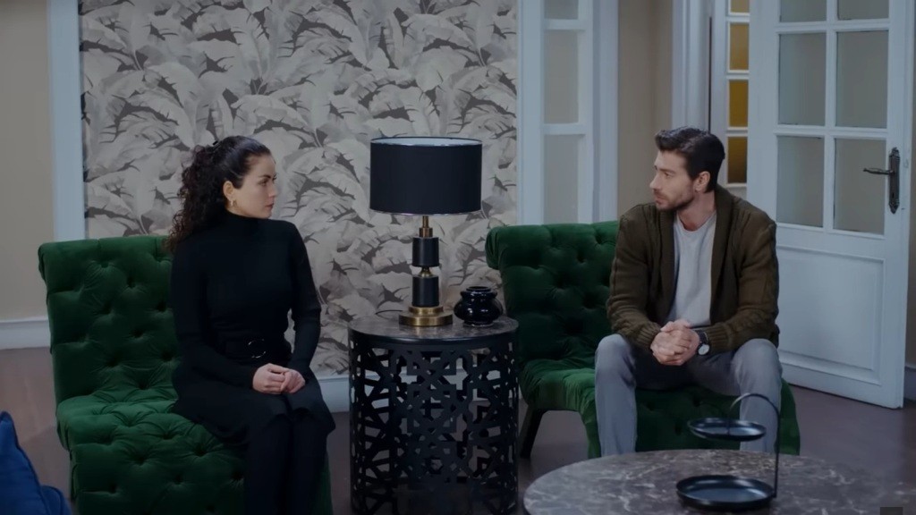 Aynur i Sinan siedzą w fotelach.