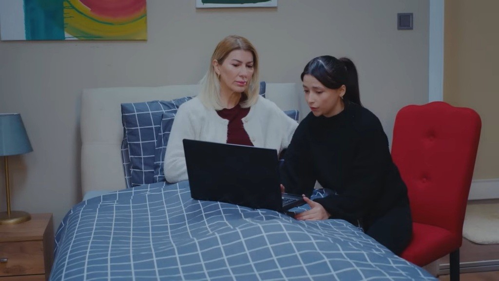 Isil i Ezgi wpatrują się w ekran laptopa.