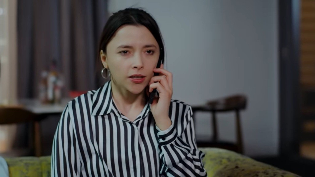 Ezgi rozmawia przez telefon. Na jej twarzy maluje się mieszanka rozpaczy i frustracji.