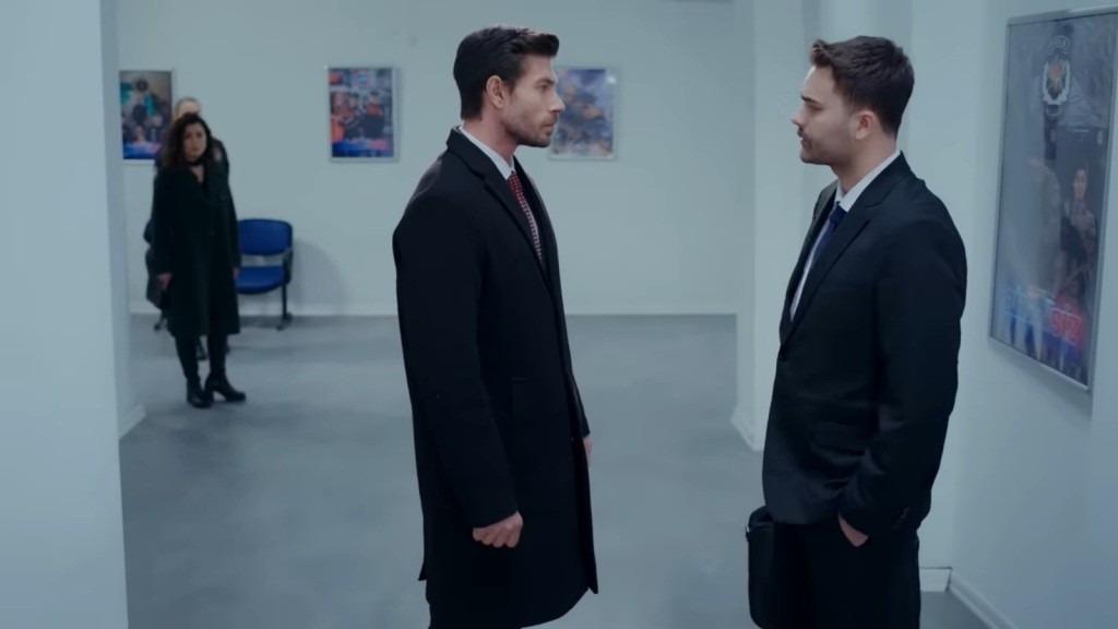 Prokuratorzy Sinan i Baran stoją twarzą w twarz na komisariacie. Na drugim planie widać sylwetkę Aynur.