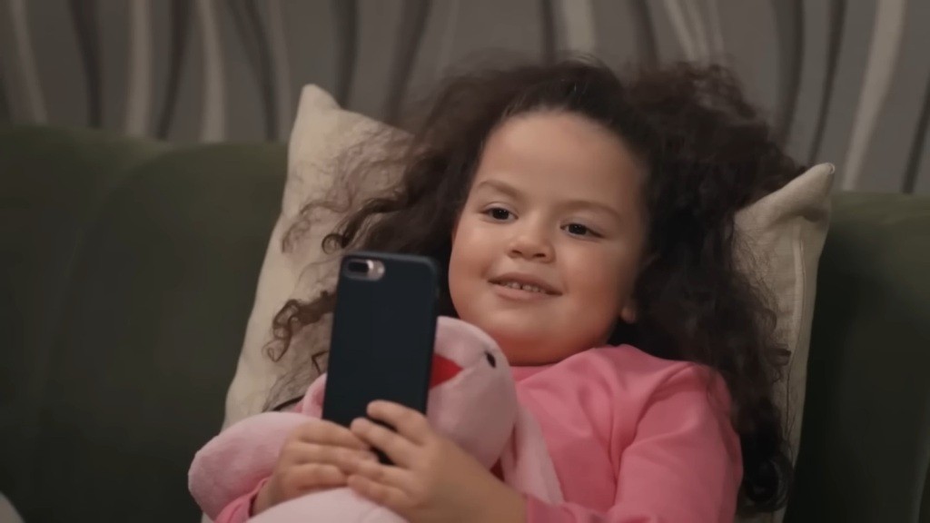 Doga trzyma w rękach misia i telefon mamy.