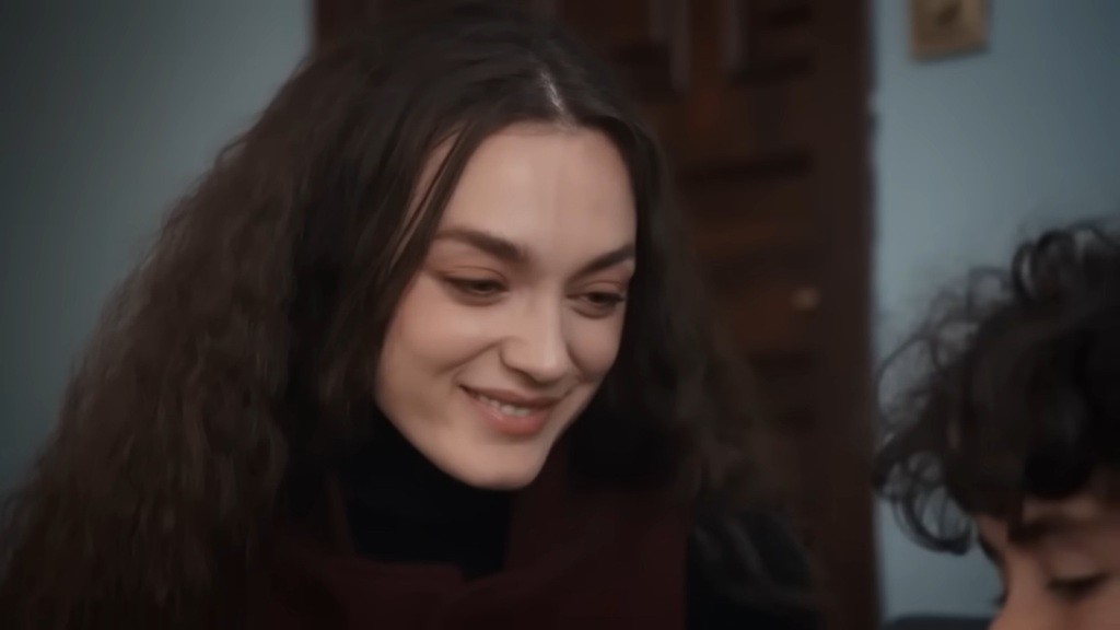 Nana uśmiecha się, patrząc na Yusufa.