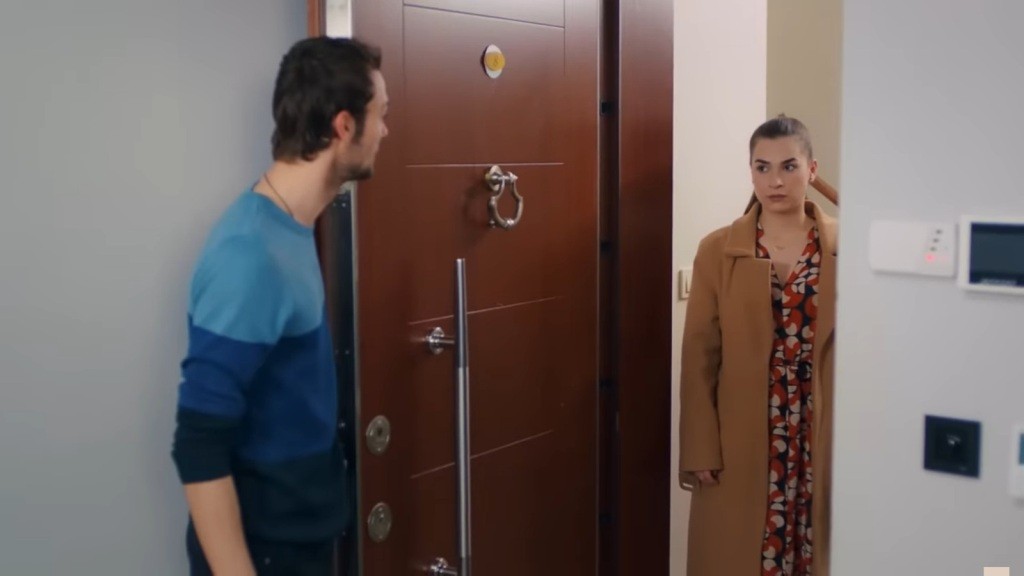 Alper otwiera drzwi. Przed wejściem stoi Sila.