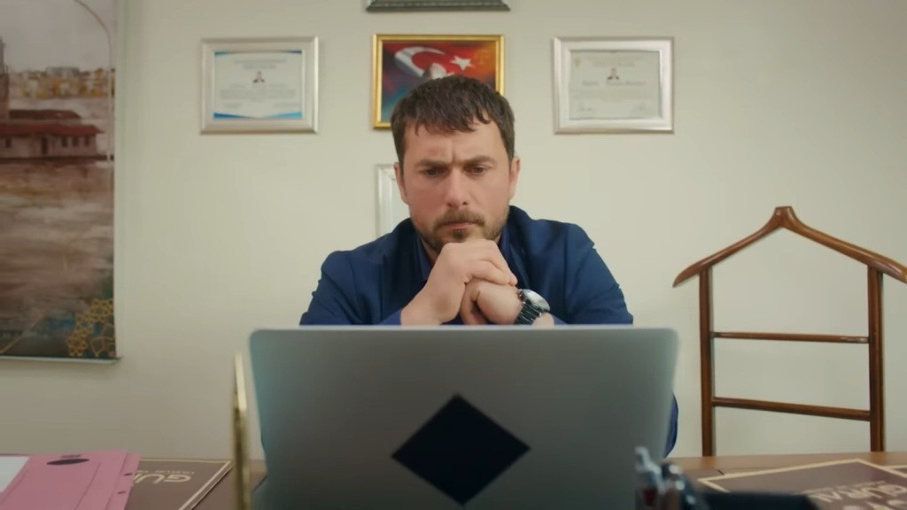 Kuzey siedzi przed laptopem.