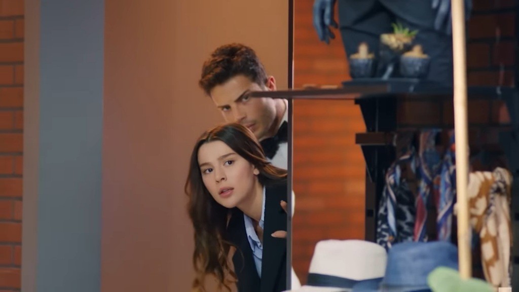 Zeynep i Ege wyglądają zza ściany.
