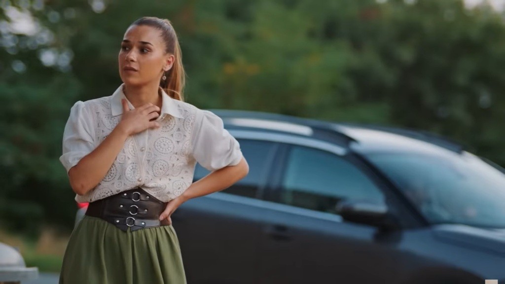 Sila rozgląda się z niepokojem. Za jej plecami stoi samochód.