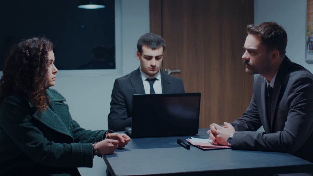 Prokurator Baran przesłuchuje Aynur. Z boku siedzi protokolant, który wszystko notuje na laptopie.