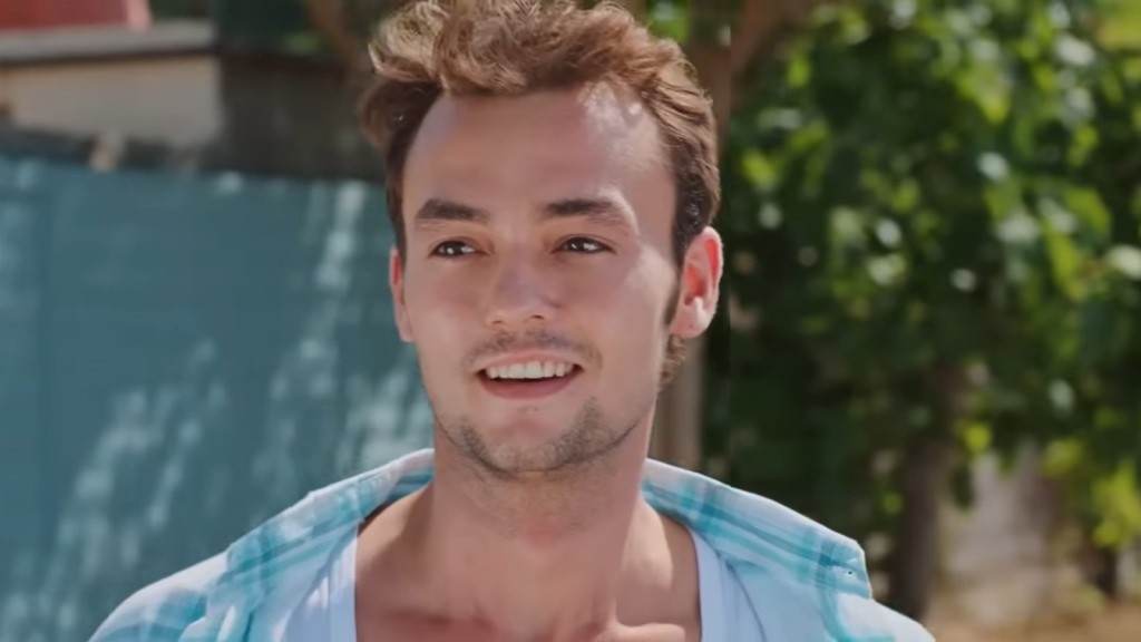 Alper uśmiecha się. Jego włosy rozwiewa wiatr.