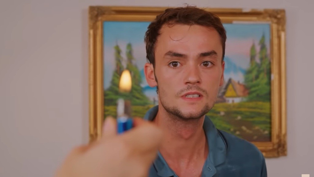 Alper z przerażeniem patrzy na palącą się zapalniczkę.