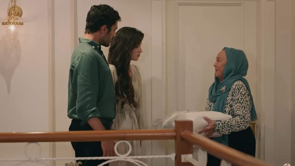 Zumrut zatrzymuje Halila i Zeynep na korytarzu. W rękach trzyma pakunek.