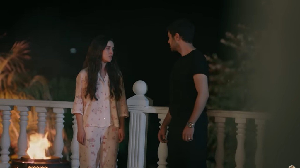 Halil stoi przed Zeynep na tarasie.