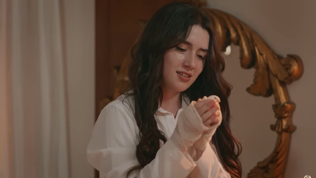 Zeynep z czułością trzyma kanarka w dłoniach.