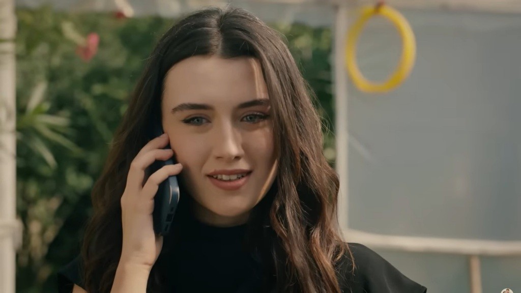 Na twarzy Zeynep maluje się pogodny uśmiech, gdy rozmawia przez telefon.