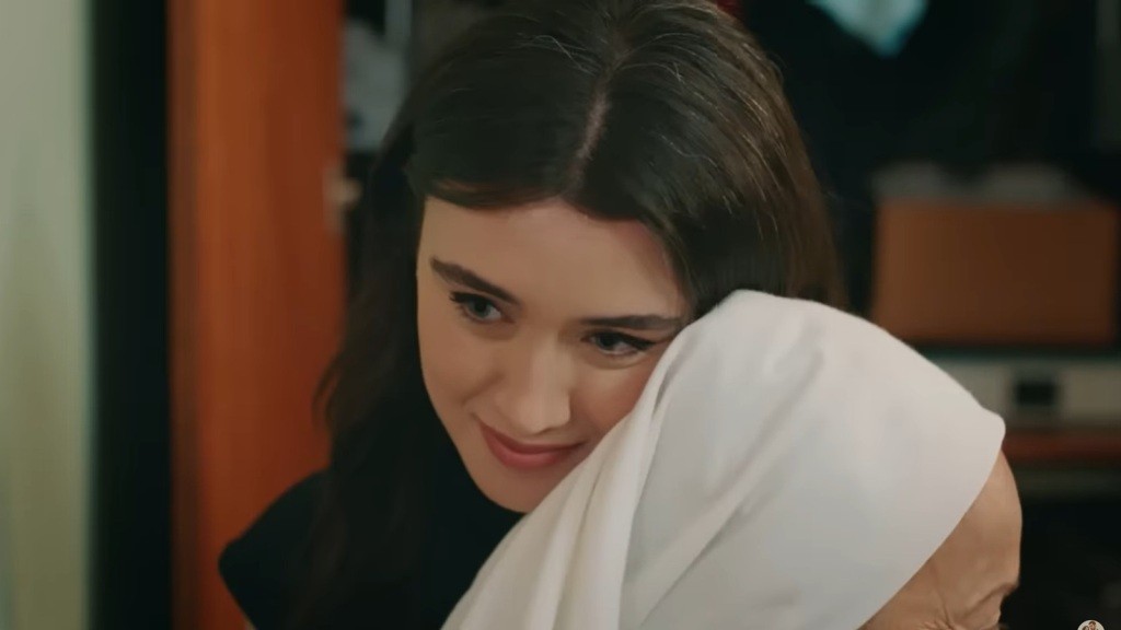 Zeynep przytula się do babci, uśmiechając się.