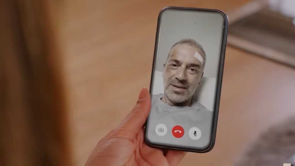 Zbliżenie na ekran telefonu Feraye, na którym wyświetlona jest twarz Bulenta znajdującego się w szpitalu.