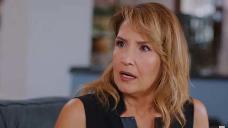 Feraye jest oszołomiona, jakby nagle wstrząsnęła nią fala nieoczekiwanych emocji. Jej oczy rozszerzają się w zdumieniu, a usta otwierają w bezgłośnym wyrazie zaskoczenia.