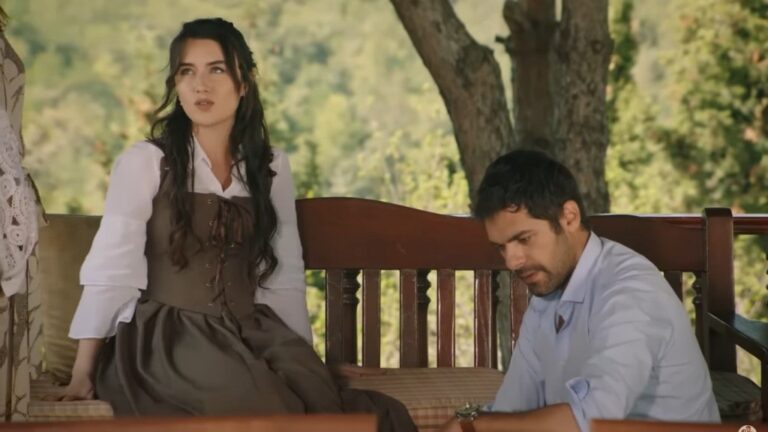 Halil klęczy przed Zeynep, która siedzi na ławce w altanie.