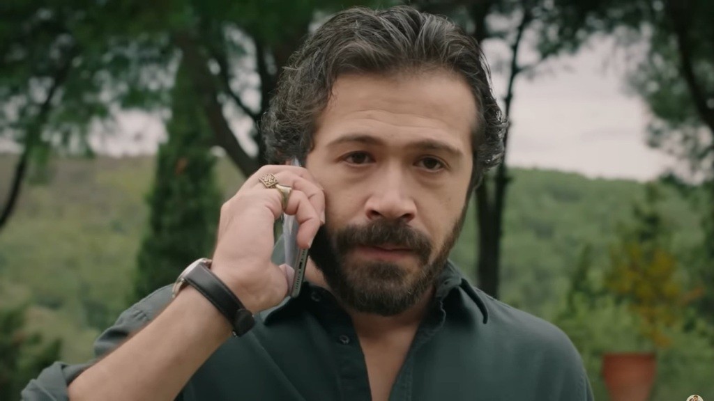 Tekin rozmawia przez telefon. Jego twarz wyraża napięcie.