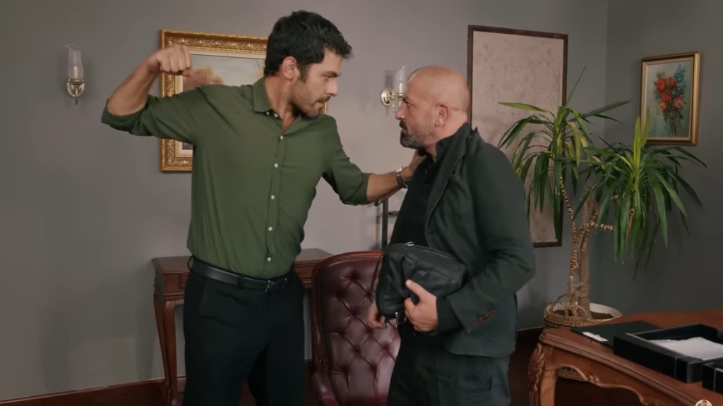 Halil stoi przed Kazimem, z pięścią uniesioną w górę, gotowy do zadania ciosu. Jego postura zdradza gniew i determinację.
