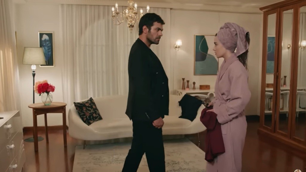 Halil podchodzi do Zeynep, która ma na sobie szlafrok i ręcznik owinięty na włosach.