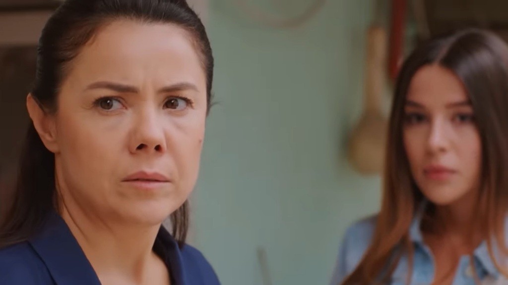 Gonul i Zeynep stoją na zewnątrz domu i patrzą w jednym kierunku.
