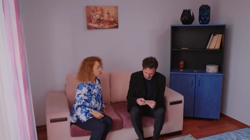 Hulya i Levent siedzą na sofie w pokoju.