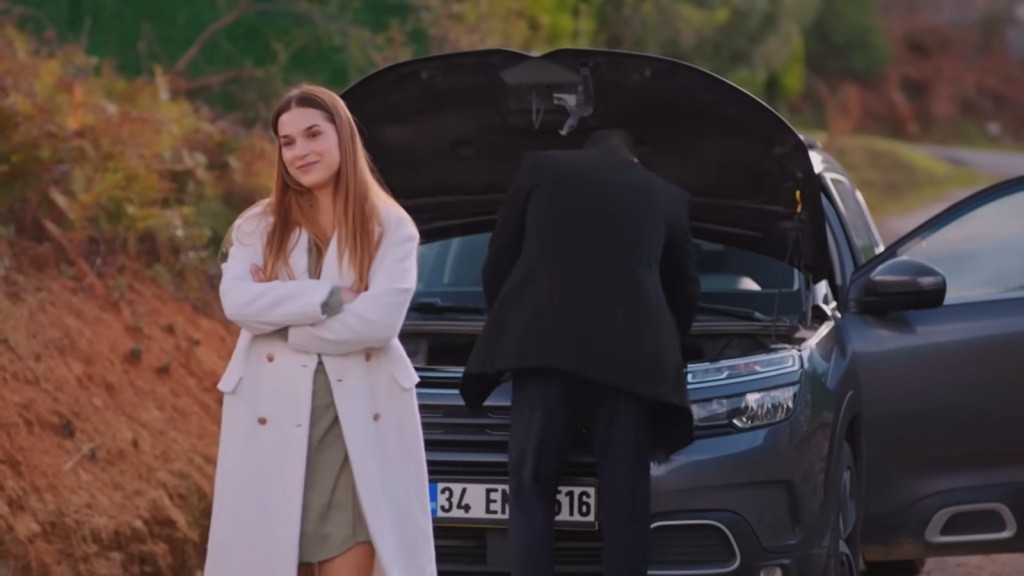 Kuzey zagląda pod maskę samochodu. Sila krzyżuje ręce na piersi i uśmiecha się.
