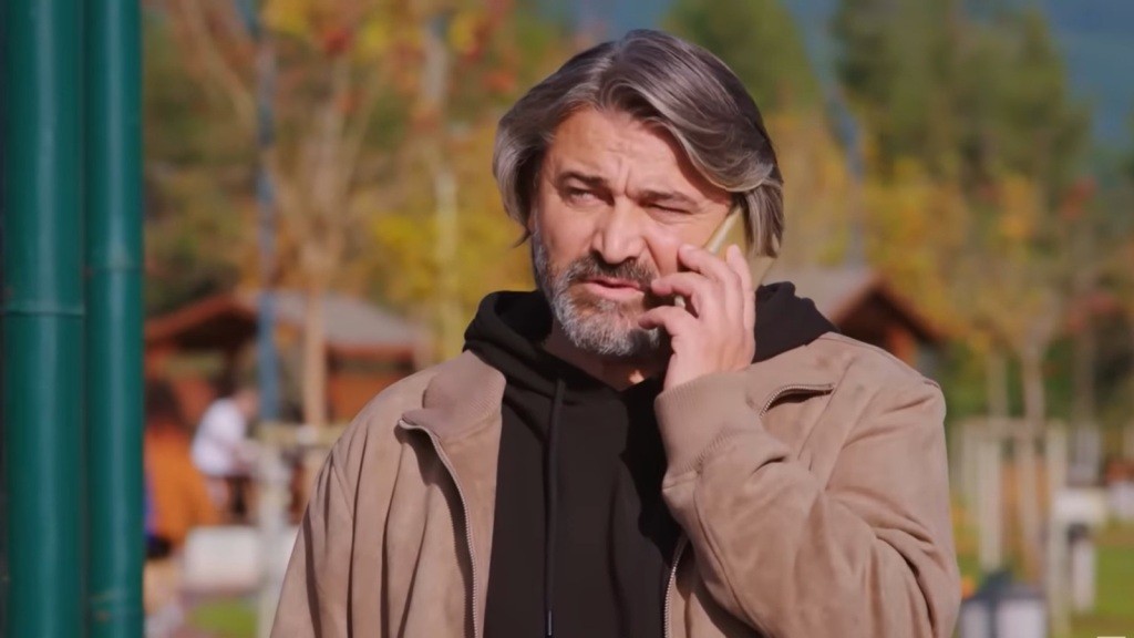 Taylan znajduje się na zewnątrz i rozmawia przez telefon.