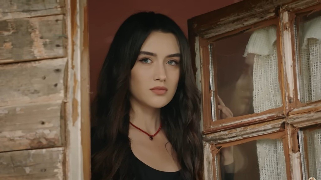 Zeynep wygląda przez otwarte okno.