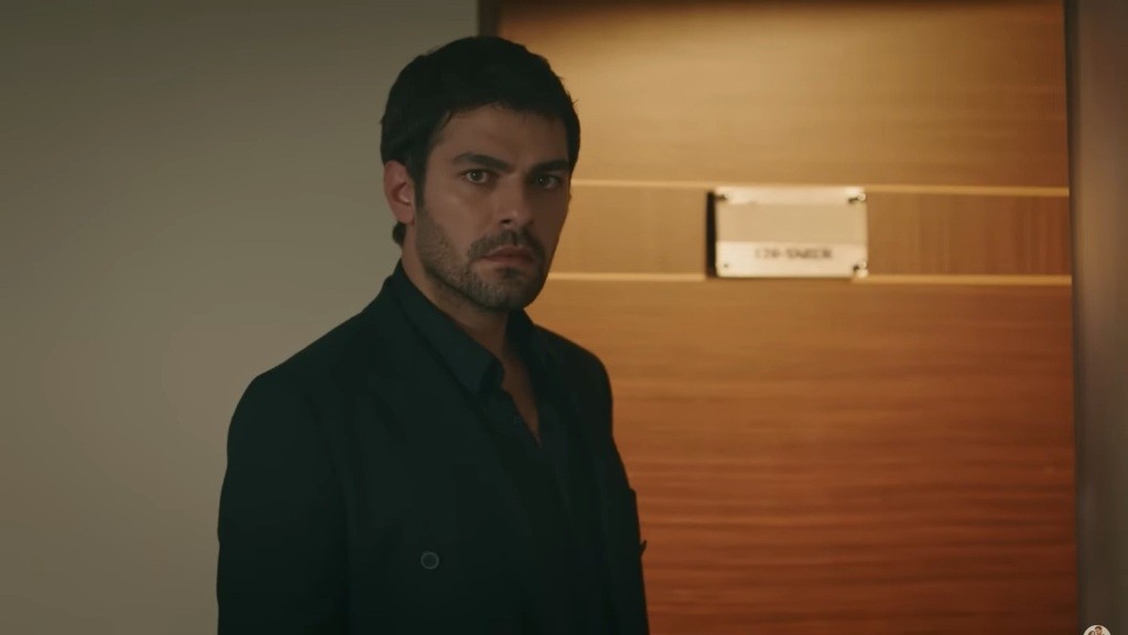 Halil wchodzi do pokoju hotelowego.