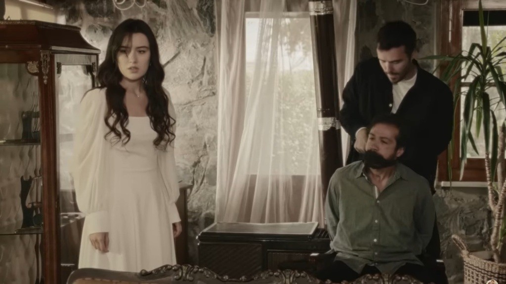 Hakan knebluje Tekina, a Zeynep stoi obok.