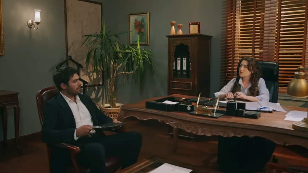 Zeynep siedzi w fotelu Halila. On sam siedzi naprzeciwko niej.