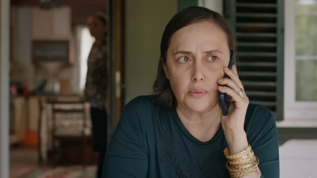 Kiymet rozmawia przez telefon na werandzie.