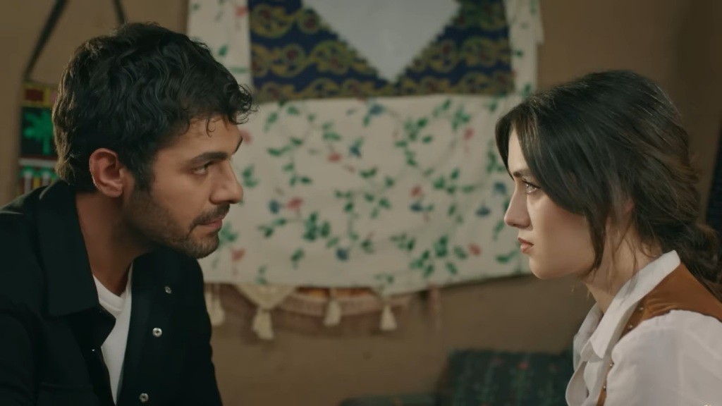 Halil i Zeynep siedzą naprzeciwko siebie i patrzą sobie prosto w oczy.